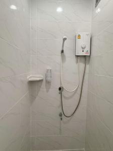 a shower in a bathroom with white tiles at Tokyo Hotel in Nakhon Ratchasima +17 photos