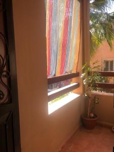 ein Fenster mit einem Regenbogen-Vorhang in einem Zimmer in der Unterkunft Ghazaly house in Marrakesch