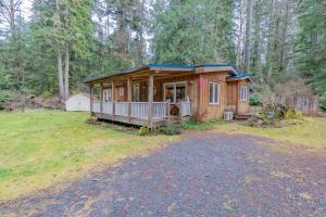 a wooden cabin in the woods with a yard at Cedar Cabin at Rainier Entrance-Hot Tub and Cinema in Ashford