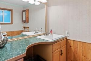 a bathroom with a sink and a large mirror at Cedar Cabin at Rainier Entrance-Hot Tub and Cinema in Ashford +10 photos