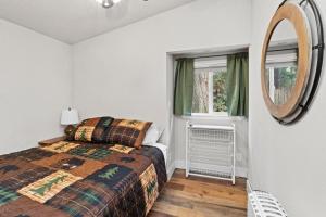 a bedroom with a bed and a mirror at Cedar Cabin at Rainier Entrance-Hot Tub and Cinema in Ashford