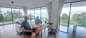 Due persone sedute a un tavolo in soggiorno di The View at Glenloch - Home Stay a Tawalantenna