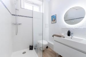 a white bathroom with a shower and a sink at Le Nautique in Valence +21 photos