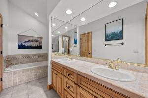 ein Badezimmer mit zwei Waschbecken und einem großen Spiegel in der Unterkunft 102 Mountain Lodge Way in Winter Park + 30 Fotos