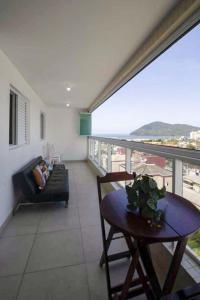 a living room with a table and a couch at Apto com lazer completo a 500m da Praia da Enseada in Bertioga