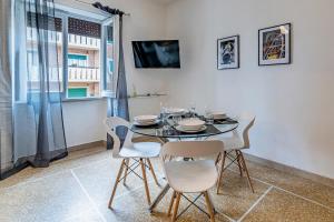 Un comedor con mesa y sillas y una ventana. en Amor Rome Apartments - 6 posti letto e 2 bagni a 4 fermate dal COLOSSEO, en Roma