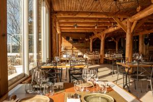 a dining room with tables and chairs and windows at Hotel des Pyrénées in Font-Romeu