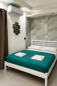 una camera da letto con un letto grande con una coperta verde di House Piazza Plebiscito by Loveinthetravel a Napoli