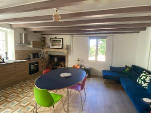 a living room with a blue table and green chairs at La Petite Grande Maison près de Chauvigny in Fleix