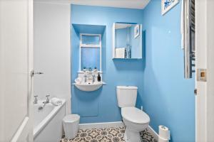Un baño azul con inodoro y lavabo. en The Old Jewellers, en Tayport