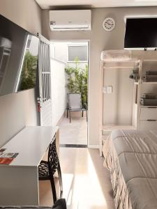 a bedroom with a bed and a desk and a tv at La Estancia Residencial in Iguape