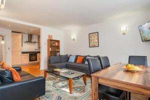 a living room with a couch and a table at The London Loftscape in London