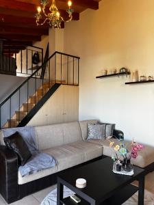 ein Wohnzimmer mit Sofa und Tisch in der Unterkunft Hidden Loft in Preveza