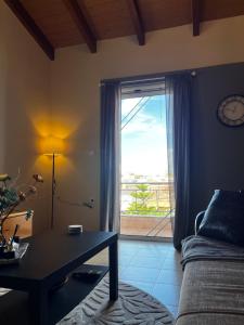 ein Wohnzimmer mit einem Tisch und einem großen Fenster in der Unterkunft Hidden Loft in Preveza