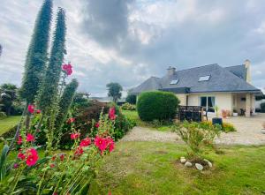 une maison avec un jardin avec des fleurs dans la cour dans l'établissement Ty Névez, à Sibiril