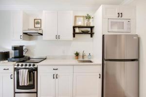 a kitchen with white cabinets and a stainless steel refrigerator at Renovated Studio in Downtown Stuart #5 in Stuart