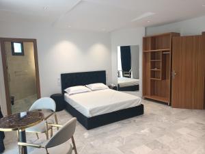 a bedroom with a bed and a table and chairs at Hôtel Tlemcen médina in Tlemcen