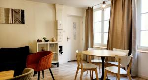 a living room with a table and chairs at Appartement en centre piétonnier proche de la gare in Thionville +15 photos