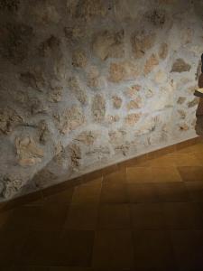 un mur de pierre dans une pièce avec un sol carrelé dans l'établissement Son morell, à Muro