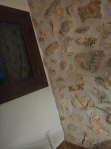 un mur en pierre avec une photo sur le mur dans l'établissement Son morell, à Muro