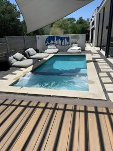 a swimming pool on a patio with cushioned chairs at Modern 2-Home Private Oasis w Pool Hot Tub in DT in Austin