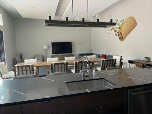 a kitchen with a sink and a living room at Modern 2-Home Private Oasis w Pool Hot Tub in DT in Austin
