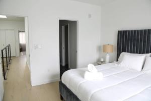 a bedroom with a large white bed with a black headboard at Modern Condo w Patio City Views Heart of DT Austin in Austin