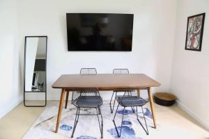 オースティンにあるUpscale 2BR Condo w Patio City Views Walk to DTの木製テーブル(椅子3脚、鏡付)