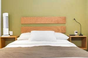 una camera da letto con un letto grande con testiera in legno di 2ndhome a Celaya