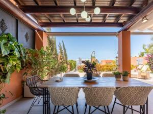 a table and chairs on a patio with plants at GS Luxury Ocean View Villa with Heated Pool by Golf in Adeje