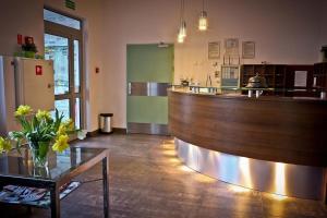 a bar in a restaurant with a counter and flowers at Hostel 24 in Bydgoszcz