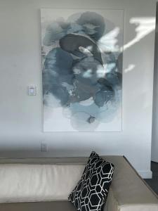 a painting on a wall above a couch with a pillow at Tailgate Penthouse 2 Blocks from UT Stadium in Austin