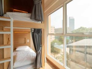 a bedroom with bunk beds and a large window at Cape Ratchada in Bangkok