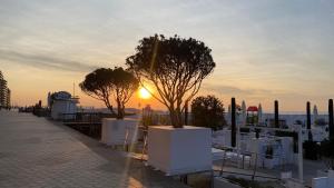 a sunset over a city with trees on a sidewalk at Orfeo Knokke in Knokke-Heist