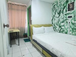 Hotel O Green Leaf Guest Lodge Kk في كوتا كينابالو: غرفة نوم صغيرة بها سرير ومكتب