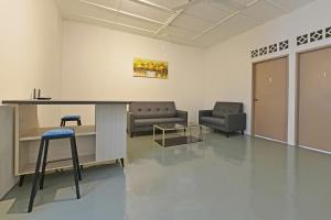 una sala d'attesa con divani, tavolo e sedie di Hotel O S Homestay a Kuantan