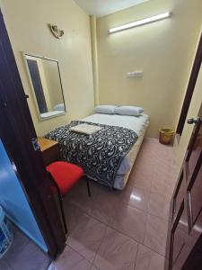 a bedroom with a bed and a mirror and a chair at Hotel O Bintang Inns in Rawang