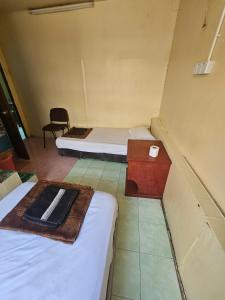 a room with two beds and a table and a chair at Hotel O Bintang Inns in Rawang