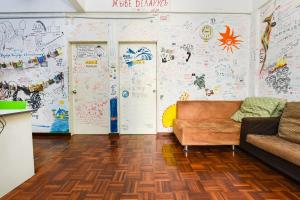 a living room with a couch and a wall with drawings at Hotel O Kuantan Backpackers in Kuantan +26 photos