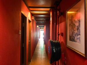 a long hallway with red walls and a tile floor at Hotel O I.villa Inn in Kuala Lumpur