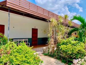 a white building with a red door and some plants at Baan Kenpoo Resort in Ban Na Pa