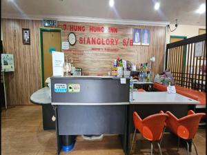 eine Bar in einem Restaurant mit orangefarbenen Stühlen in der Unterkunft Hotel O Sianglory Inn in Kota Kinabalu