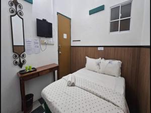 ein kleines Schlafzimmer mit einem Bett und einem Fernseher in der Unterkunft Hotel O Sianglory Inn in Kota Kinabalu + 38 Fotos