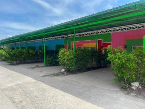 a brightly colored building with a green roof at OYO 75487 Prang Thip 306 Resort in Bangkok