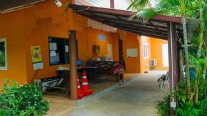an orange building with a patio with a dog in it at The Moon Resort Phetchaburi in Phetchaburi +49 photos