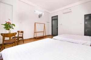 2 letti in una camera con tavolo e sedia di SPOT ON 806 Net Viet Homestay a Da Nang