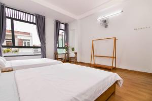 una camera da letto con due letti e una finestra di SPOT ON 806 Net Viet Homestay a Da Nang
