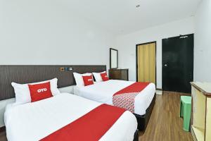 a hotel room with two beds with red and white sheets at Hotel O Mini Indah in Kuala Terengganu +33 photos
