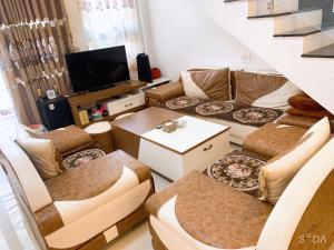 un salon avec des canapés et une télévision à écran plat dans l'établissement OYO 1248 Quyen House, à Đà Lạt