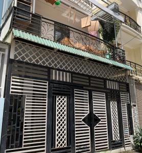 - un bâtiment noir et blanc avec un balcon dans l'établissement OYO 1248 Quyen House, à Đà Lạt